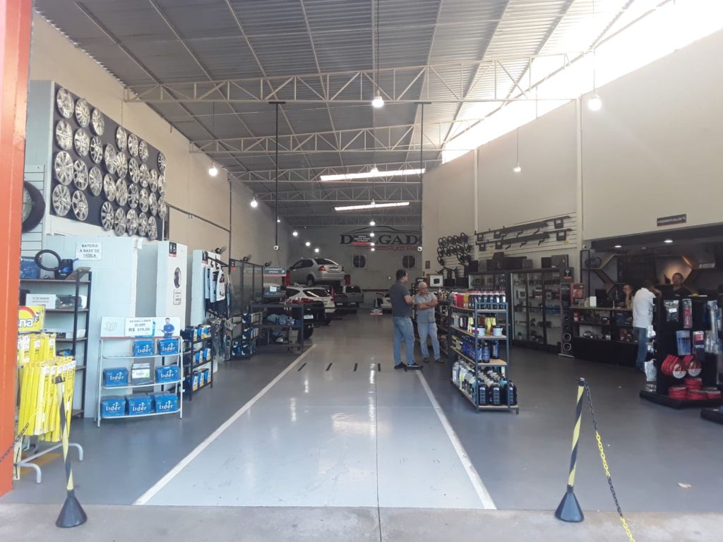 Interior da Delgado Auto Parts em Birigui, com acessórios em exposição e área de instalação ao fundo