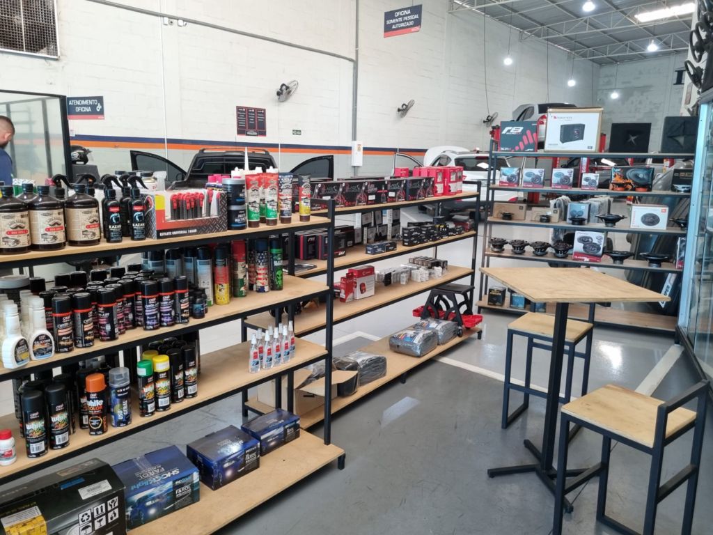 Interior do barracão da Delgado Auto Parts em Birigui, com exposição de acessórios e veículos na área de instalação